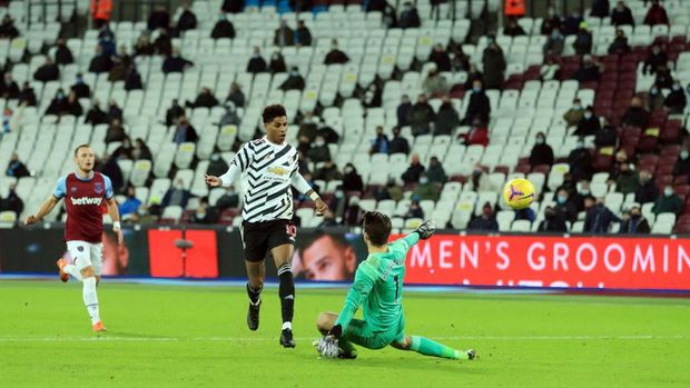 LONDON, ENGLAND - DECEMBER 05: Marcus Rashford of Manchester United scores his team's third goal after Lukasz Fabianski of West Ham United during the Premier League match between West Ham United and Manchester United at London Stadium on 05 December 2020 in London, England.  A limited number of fans are welcome to the stadiums to watch elite football in England.  This was after the loosening of spectator restrictions in the level one and two areas only.  (Photo by Adam Davy - Pool / Getty Images)