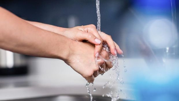 Cropped image of woman washing hands in kitchen at home