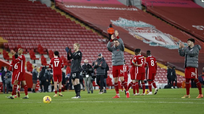 LIVERPOOL, ENGLAND - DECEMBER 06: Caoimhin Kelleher and Jordan Henderson of Liverpool along with team mates applaud the few fans allowed in the Kop after the Premier League match between Liverpool and Wolverhampton Wanderers at Anfield on December 06, 2020 in Liverpool, England. A limited number of fans (2000) are welcomed back to stadiums to watch elite football across England. This was following easing of restrictions on spectators in tiers one and two areas only. (Photo by Clive Brunskill/Getty Images)