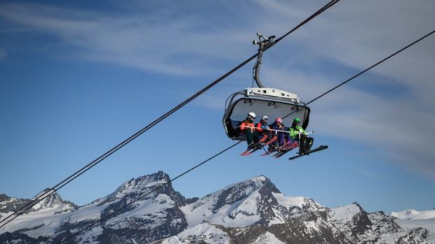 Wisata Ski di Swiss Ramai Kembali Dikunjungi Turis Skiers ride a ski lift before hitting the slopes amid the COVID-19 outbreak, caused by the novel coronavirus, above the ski resort of Zermatt in the Swiss Alps on November 28, 2020. - As EU countries debate a bloc-wide ban on ski holidays to curb coronavirus infections, downhill enthusiasts may be tempted to head to non-member Switzerland, where the winter season is well underway. (Photo by Fabrice COFFRINI / AFP)