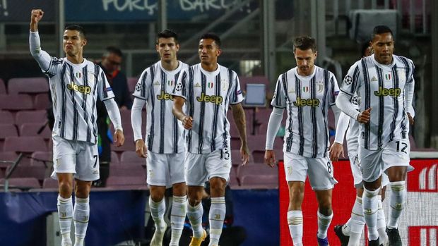 Juventus' Cristiano Ronaldo, left, celebrates after scoring his side's first goal during the Champions League group G soccer match between FC Barcelona and Juventus at the Camp Nou stadium in Barcelona, Spain, Tuesday, Dec. 8, 2020. (AP Photo/Joan Monfort)