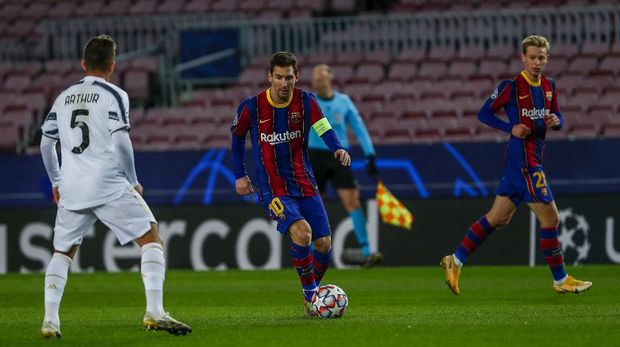Barcelona's Lionel Messi, center, controls the ball next to Juventus' Arthur during the Champions League group G soccer match between FC Barcelona and Juventus at the Camp Nou stadium in Barcelona, Spain, Tuesday, Dec. 8, 2020. (AP Photo/Joan Monfort)