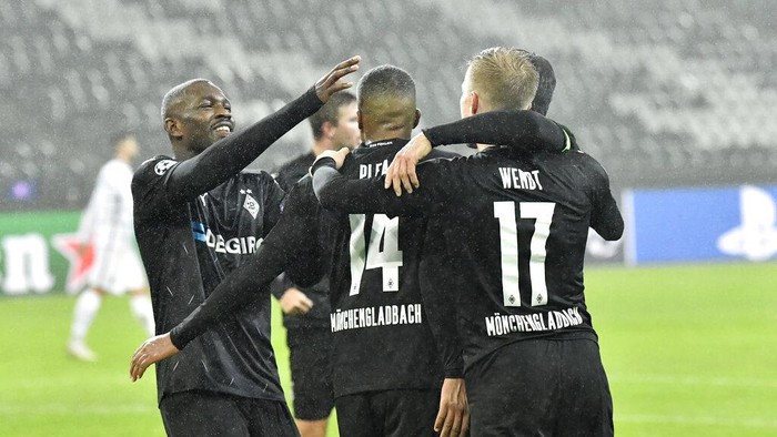 Moenchengladbachs Alassane Plea, center, celebrates after scoring his sides opening goal during the Champions League, Group B, soccer match between Borussia Moenchengladbach and Inter Milan at the Borussia Park in Moenchengladbach, Germany, Tuesday, Dec. 1, 2020. (AP Photo/Martin Meissner)
