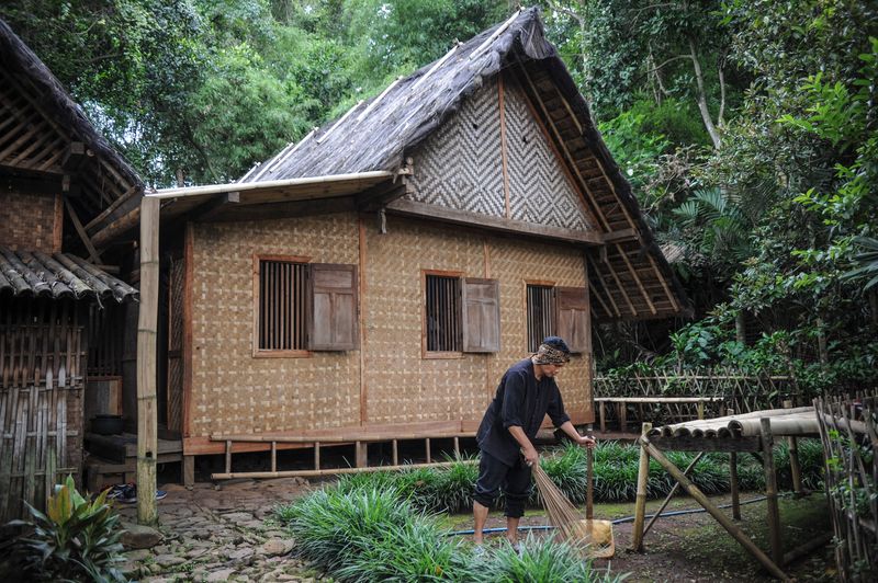 Seorang warga membersihkan halaman rumah di Kampung Adat Cikondang, Lamajang, Pangalengan, Kabupaten Bandung, Jawa Barat, Rabu (9/12/2020). Kampung Adat Cikondang yang telah ada sejak abad ke-19 dan memiliki beberapa peninggalan leluhur kampung tersebut saat ini telah ditetapkan pemerintah sebagai cagar budaya. ANTARA FOTO/Raisan Al Farisi/wsj.