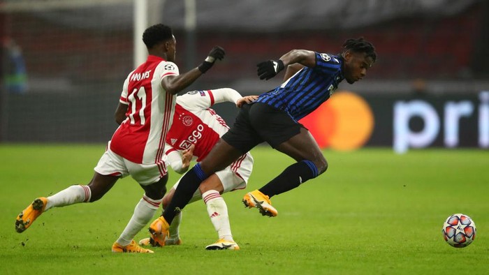 AMSTERDAM, NETHERLANDS - DECEMBER 09: Duvan Zapata of Atalanta B.C. is tackled by Quincy Promes and Lisandro Martinez of Ajax during the UEFA Champions League Group D stage match between Ajax Amsterdam and Atalanta BC at Johan Cruijff Arena on December 09, 2020 in Amsterdam, Netherlands. Sporting stadiums around Natherlands remain under strict restrictions due to the Coronavirus Pandemic as Government social distancing laws prohibit fans inside venues resulting in games being played behind closed doors. (Photo by Dean Mouhtaropoulos/Getty Images)