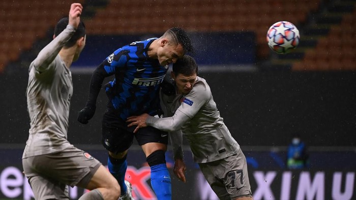 Inter Milans Argentine forward Lautaro Martinez (C) shoots a header on goal despite Shakhtar Donetsks Ukrainian defender Valeriy Bondar (R) during the UEFA Champions League Group B football match Inter Milan vs Shakhtar Donetsk on December 9, 2020 at the Giuseppe-Meazza (San Siro) stadium in Milan. (Photo by Marco BERTORELLO / AFP)