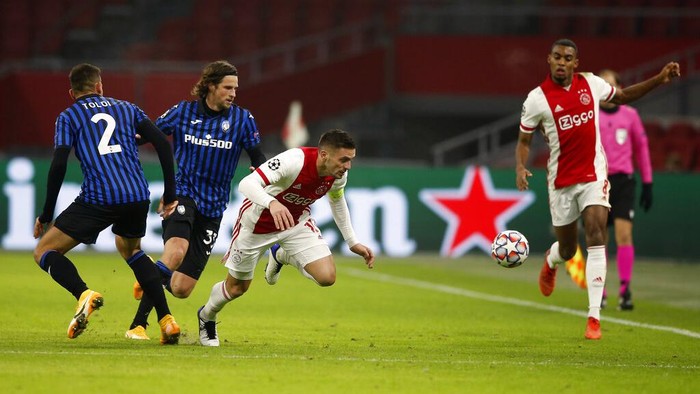 Ajaxs Dusan Tadic, centre, duels for the ball with Atalantas Rafael Toloi, left, and Atalantas Hans Hateboer during the group D Champions League soccer match between Ajax and Atalanta at the Johan Cruyff ArenA in Amsterdam, Netherlands, Wednesday, Dec. 9, 2020. (AP Photo/Peter Dejong)