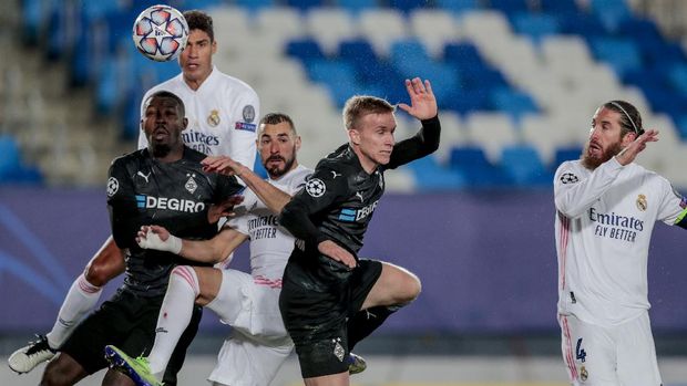 Real Madrid's Karim Benzema, center, vies for the ball next to Real Madrid's Raphael Varane, second left, and Real Madrid's Sergio Ramos, right, against Moenchengladbach's Marcus Thuram, left, during the Champions League group B soccer match between Real Madrid and Borussia Monchengladbach at the Alfredo Di Stefano stadium in Madrid, Spain, Wednesday, Dec. 9, 2020. (AP Photo/Bernat Armangue)