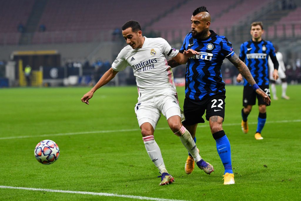 MILAN, ITALY - NOVEMBER 25: Lucas Vazquez of Real Madrid is challenged by Arturo Vidal of Inter Milan during the UEFA Champions League Group B stage match between FC Internazionale and Real Madrid at Stadio Giuseppe Meazza on November 25, 2020 in Milan, Italy. Football Stadiums around Europe remain empty due to the Coronavirus Pandemic as Government social distancing laws prohibit fans inside venues resulting in fixtures being played behind closed doors. (Photo by Valerio Pennicino/Getty Images)