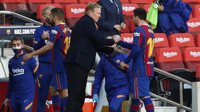 Barcelonas head coach Ronald Koeman shakes hands with Barcelonas Lionel Messi at the end of the Spanish La Liga soccer match between FC Barcelona and Osasuna at the Camp Nou stadium in Barcelona, Spain, Sunday, Nov. 29, 2020. (AP Photo/Joan Monfort)