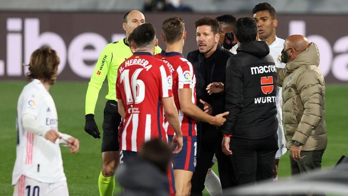 MADRID, SPAIN - DECEMBER 12: Marcos Llorente of Atletico de Madrid (obscured) appeals to match referee Antonio Miguel Mateu Lahoz as Diego Simeone, Head Coach of Atletico de Madrid holds him back during the La Liga Santander match between Real Madrid and Atletico de Madrid at Estadio Alfedo Di Stefano on December 12, 2020 in Madrid, Spain. Sporting stadiums around Spain remain under strict restrictions due to the Coronavirus Pandemic as Government social distancing laws prohibit fans inside venues resulting in games being played behind closed doors. (Photo by Angel Martinez/Getty Images)