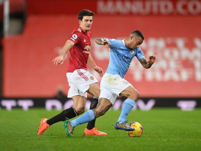 MANCHESTER, ENGLAND - DECEMBER 12: Gabriel Jesus of Manchester City and Harry Maguire of Manchester United  battle for the ball during the Premier League match between Manchester United and Manchester City at Old Trafford on December 12, 2020 in Manchester, England. The match will be played without fans, behind closed doors as a Covid-19 precaution. (Photo by Michael Regan/Getty Images)