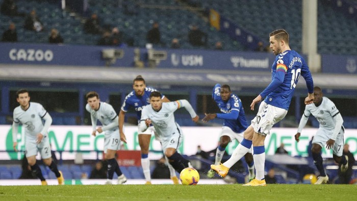Evertons Gylfi Sigurdsson, front, scores his sides opening goal from penalty spot during the English Premier League soccer match between Everton and Chelsea at Goodison Park in Liverpool, England, Saturday, Dec. 12, 2020. (Clive Brunskill/Pool via AP)