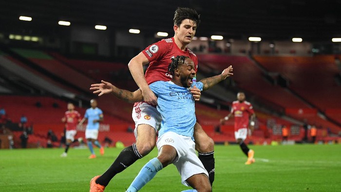 MANCHESTER, ENGLAND - DECEMBER 12: Raheem Sterling of Manchester City and Harry Maguire of Manchester United battle for the ball during the Premier League match between Manchester United and Manchester City at Old Trafford on December 12, 2020 in Manchester, England. The match will be played without fans, behind closed doors as a Covid-19 precaution. (Photo by Michael Regan/Getty Images)
