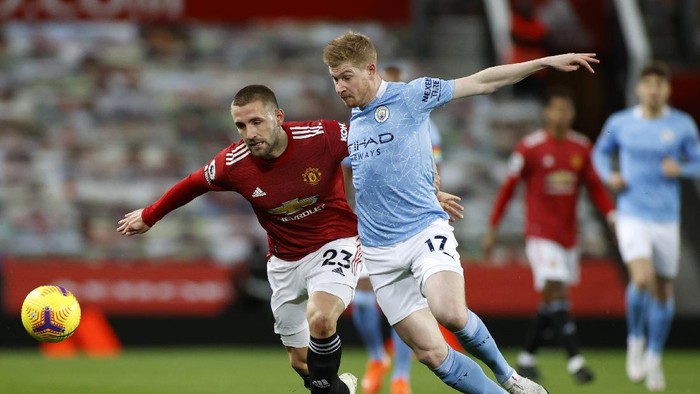 MANCHESTER, ENGLAND - DECEMBER 12: Luke Shaw of Manchester United and Kevin De Bruyne of Manchester City  battle for the ball  during the Premier League match between Manchester United and Manchester City at Old Trafford on December 12, 2020 in Manchester, England. The match will be played without fans, behind closed doors as a Covid-19 precaution. (Photo by Phil Noble - Pool/Getty Images)