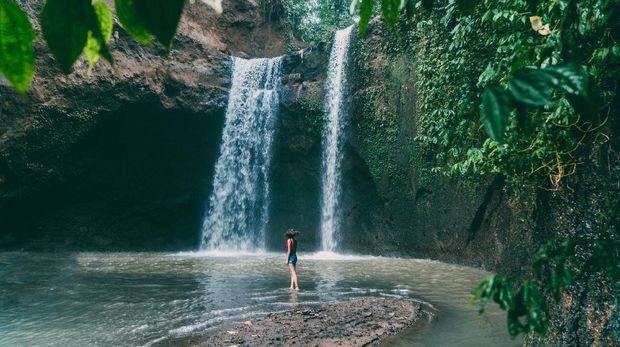 Air Terjun Tibumana di Bali Young Caucasian woman walking near Tibumana waterfall in Bali, Indonesia