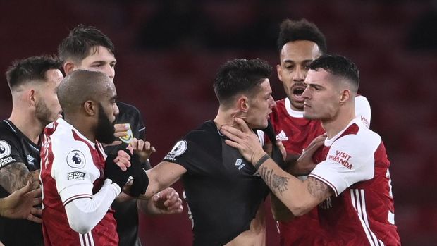 Arsenal's Granit Xhaka, right, grabs Burnley's Ashley Westwood by the throat during an English Premier League soccer match between Arsenal and Burnley at the Emirates stadium in London, England, Sunday Dec. 13, 2020. (Laurence Griffiths/Pool via AP)