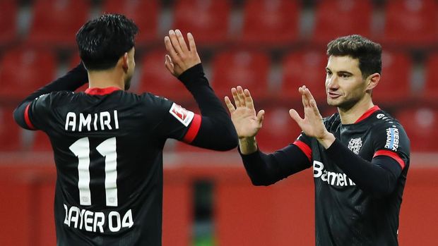Bayer Leverkusen's Lucas Alario, right, celebrates scoring with Nadiem Amiri during the Bundesliga soccer match between Bayer Leverkusen v TSG 1899 Hoffenheim in the BayArena, Leverkusen, Germany, Sunday Dec. 13, 2020. (Thilo Schmuelgen/Pool via AP)