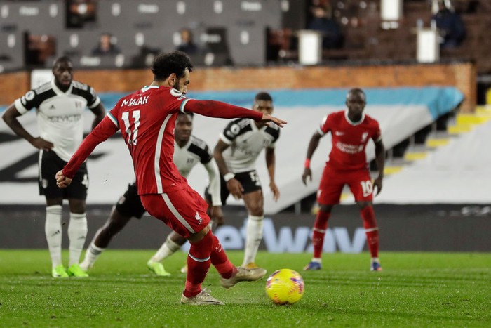 Fulham vs Liverpool LONDON, ENGLAND - DECEMBER 13: Mohamed Salah of Liverpool scores their team's first goal from the penalty spot during the Premier League match between Fulham and Liverpool at Craven Cottage on December 13, 2020 in London, England. A limited number of spectators (2000) are welcomed back to stadiums to watch elite football across England. This was following easing of restrictions on spectators in tiers one and two areas only. (Photo by Matt Dunham - Pool/Getty Images)