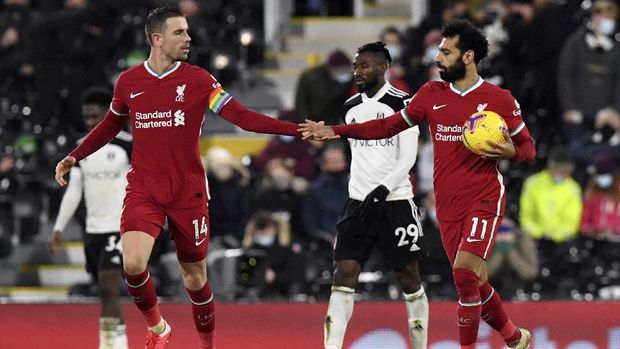 Liverpool's Jordan Henderson congratulates teammate Mohamed Salah after he scored a penalty during the English Premier League soccer match between Fulham and Liverpool, at Craven Cottage stadium, London, Sunday, Dec. 13, 2020. (Neil Hall/Pool via AP)