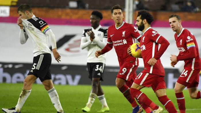 Liverpools Mohamed Salah retrieves the ball after scoring his sides first goal during the English Premier League soccer match between Fulham and Liverpool, at Craven Cottage stadium, London, Sunday, Dec. 13, 2020. (Mike Hewitt/Pool via AP)