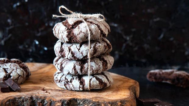 Chocolate Crinkles for a gift. Chocolate cookies in powdered sugar on a wooden board. Christmas Time.