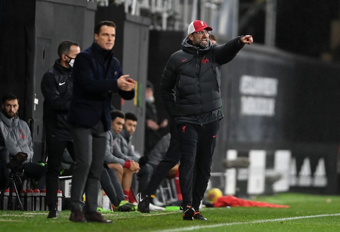 LONDON, ENGLAND - DECEMBER 13: Jurgen Klopp, Manager of Liverpool  gives their team instructions as Scott Parker, Manager of Fulham looks on during the Premier League match between Fulham and Liverpool at Craven Cottage on December 13, 2020 in London, England. A limited number of spectators (2000) are welcomed back to stadiums to watch elite football across England. This was following easing of restrictions on spectators in tiers one and two areas only. (Photo by Mike Hewitt/Getty Images)