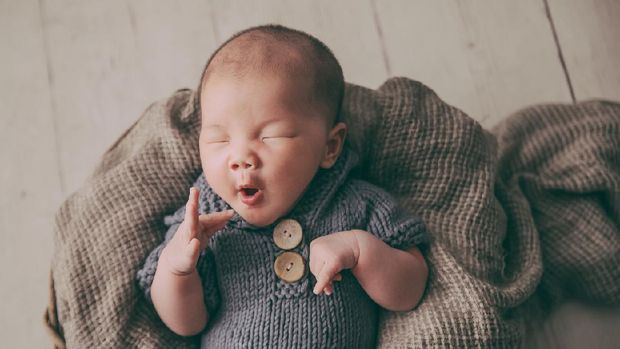 Cute baby boy with beautiful blue eyes on the white background