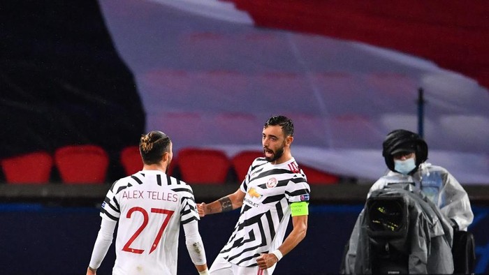 Manchester Uniteds Portuguese midfielder Bruno Fernandes (R) celebrates with Manchester Uniteds Brazilian defender Alex Telles after scoring a penalty kick during the UEFA Champions League Group H first-leg football match between Paris Saint-Germain (PSG) and Manchester United at the Parc des Princes stadium in Paris on October 20, 2020. (Photo by FRANCK FIFE / AFP)