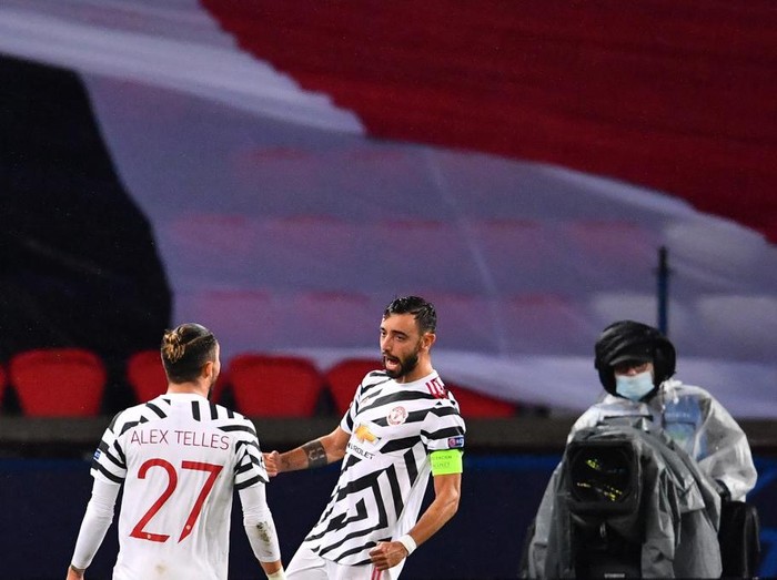 Manchester Uniteds Portuguese midfielder Bruno Fernandes (R) celebrates with Manchester Uniteds Brazilian defender Alex Telles after scoring a penalty kick during the UEFA Champions League Group H first-leg football match between Paris Saint-Germain (PSG) and Manchester United at the Parc des Princes stadium in Paris on October 20, 2020. (Photo by FRANCK FIFE / AFP)