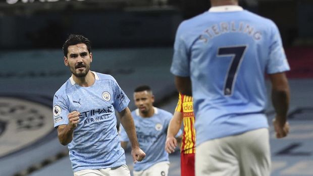 Manchester City's Ilkay Gundogan, left celebrates after scoring the opening goal of the game during their English Premier League soccer match between Manchester City and West Bromwich Albion at the Etihad Stadium in Manchester, England, Tuesday, Dec., 15 2020. (Martin Rickett/ Pool via AP)