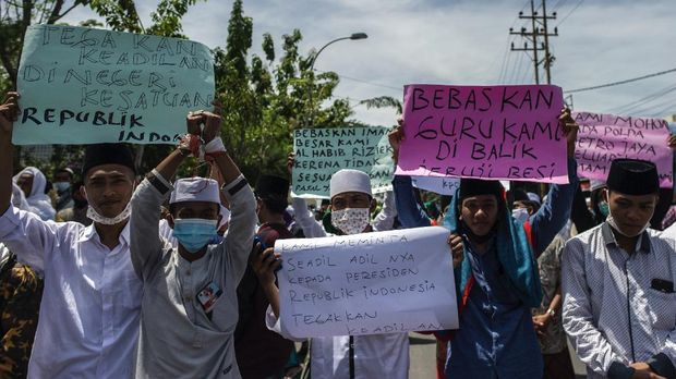 Supporters of Indonesian Muslim cleric Rizieq Shihab gather to protest outside the police headquarters in Sampang on December 16, 2020, to demand justice for six of their members killed in a shoot out with the police in Jakarta on December 7, 2020. (Photo by Juni Kriswanto / AFP)