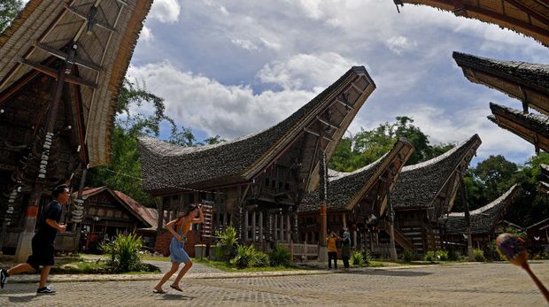 Wisatawan mengunjungi rumah adat Torajat di kawasan wisata Ketekesu, Toraja Utara, Sulawesi Selatan. Rabu (16/12/2020). Sejak ditetapkan jadi wilayah Zona Hijau di akhir Oktober lalu, sejumlah tempat wisata di Toraja Utara mulai ramai dikunjungi wisatawan dengan menerapkan protokol kesehatan. ANTARA FOTO/Zabur Karuru/foc.