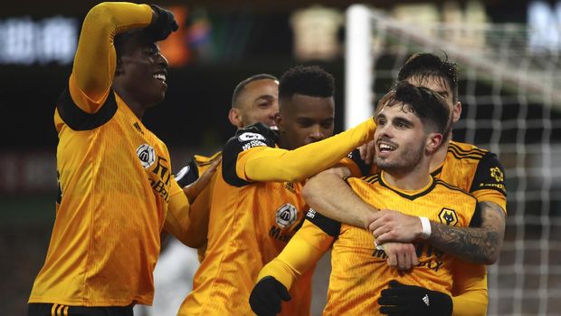 Wolverhampton Wanderers' Pedro Neto, right, celebrates with his teammates his goal against Chelsea during the English Premier League soccer match between Wolverhampton Wanderers and Chelsea at the Molineux Stadium in Wolverhampton, England, Tuesday, Dec. 15, 2020. (Michael Steele/Pool via AP)