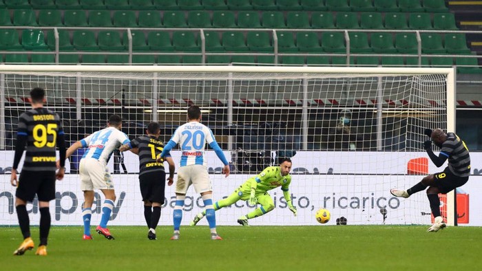 MILAN, ITALY - DECEMBER 16: Romelu Lukaku of Inter Milan scores their teams first goal from the penalty spot past David Ospina of S.S.C. Napoli  during the Serie A match between FC Internazionale and SSC Napoli at Stadio Giuseppe Meazza on December 16, 2020 in Milan, Italy. Sporting stadiums around Italy remain under strict restrictions due to the Coronavirus Pandemic as Government social distancing laws prohibit fans inside venues resulting in games being played behind closed doors. (Photo by Marco Luzzani/Getty Images )