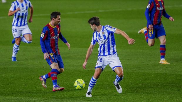 Barcelona's Lionel Messi, second left, vies for the ball with Real Sociedad's Ander Guevara during the Spanish La Liga soccer match between FC Barcelona and Real Sociedad at the Camp Nou stadium in Barcelona, Spain, Wednesday, Dec. 16, 2020. (AP Photo/Joan Monfort)