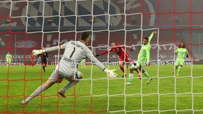 MUNICH, GERMANY - DECEMBER 16: Robert Lewandowski of Bayern Munich scores their teams second goal past Koen Casteels of VfL Wolfsburg during the Bundesliga match between FC Bayern Muenchen and VfL Wolfsburg at Allianz Arena on December 16, 2020 in Munich, Germany. Sporting stadiums around Germany remain under strict restrictions due to the Coronavirus Pandemic as Government social distancing laws prohibit fans inside venues resulting in games being played behind closed doors. (Photo by Alexander Hassenstein/Getty Images)