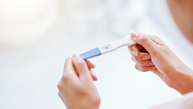 Cropped shot of a young woman taking a pregnancy test