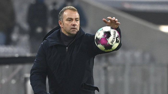 Bayern coach Hansi Flick catches the match ball during a German Bundesliga soccer match between Bayern Munich and RB Leipzig in Munich, Germany, Saturday, Dec. 5, 2020. (Sven Hoppe/dpa via AP)