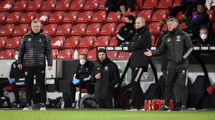 SHEFFIELD, ENGLAND - DECEMBER 17: Chris Wilder, Manager of Sheffield United looks on as Ole Gunnar Solskjaer, Manager of Manchester United gives their team instructions during the Premier League match between Sheffield United and Manchester United at Bramall Lane on December 17, 2020 in Sheffield, England. The match will be played without fans, behind closed doors as a Covid-19 precaution.  (Photo by Peter Powell - Pool/Getty Images)