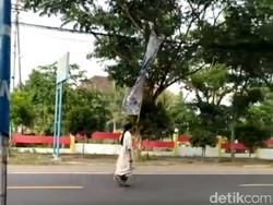 Sebelum Salat di Jalan, Pria Bergamis Ini Berjalan Antara Lalu Lalang Kendaraan