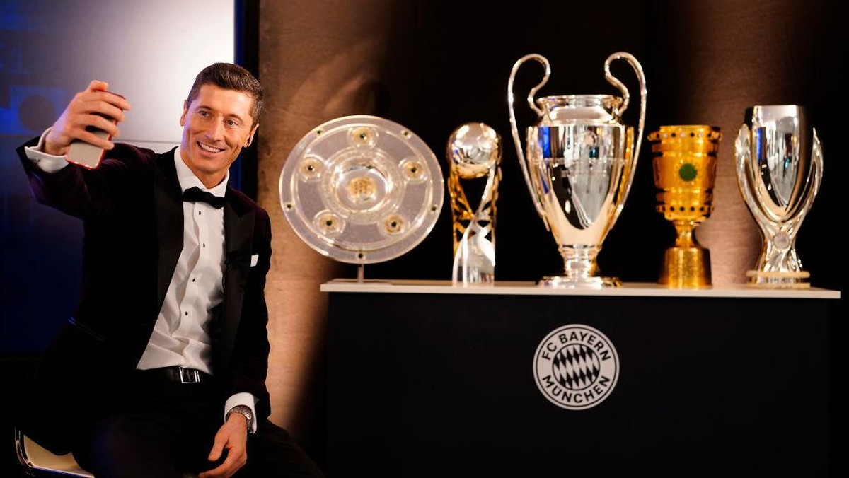 Lewandowski berswafoto dengan trofi yang diraih bersama Bayern Munich musim lalu. Foto: Marco Donato-FC Bayern/Pool via /Pool