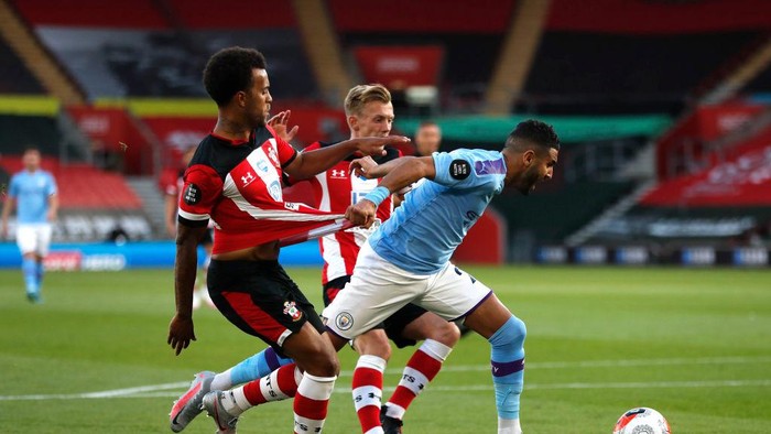 SOUTHAMPTON, ENGLAND - JULY 05: Riyad Mahrez of Manchester City is challenged by Ryan Bertrand of Southampton during the Premier League match between Southampton FC and Manchester City at St Marys Stadium on July 05, 2020 in Southampton, England. Football Stadiums around Europe remain empty due to the Coronavirus Pandemic as Government social distancing laws prohibit fans inside venues resulting in games being played behind closed doors. (Photo by Frank Augstein/Pool via Getty Images)