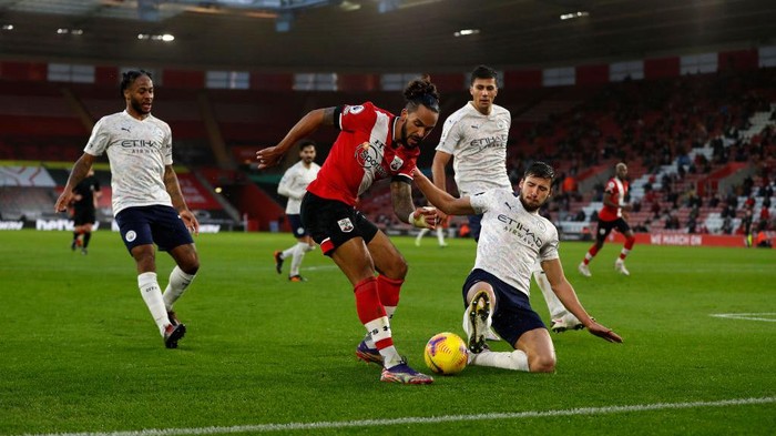 SOUTHAMPTON, ENGLAND - DECEMBER 19: Theo Walcott of Southampton is challenged by Ruben Dias of Manchester City during the Premier League match between Southampton and Manchester City at St Marys Stadium on December 19, 2020 in Southampton, England. A limited number of fans (2000) are welcomed back to stadiums to watch elite football across England. This was following easing of restrictions on spectators in tiers one and two areas only. (Photo by Paul Childs - Pool/Getty Images)