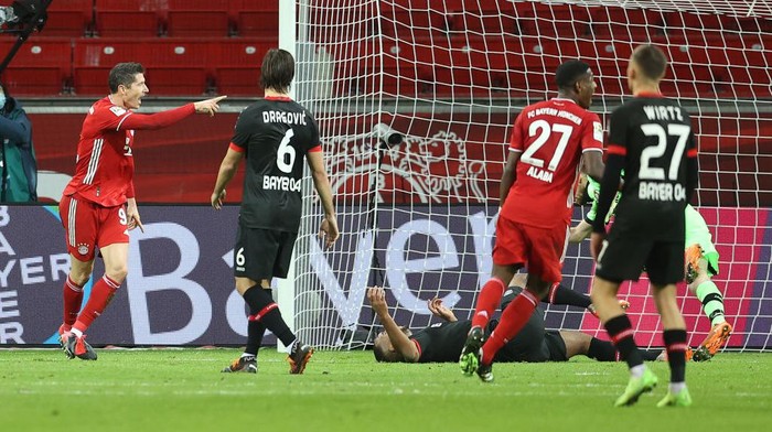 LEVERKUSEN, GERMANY - DECEMBER 19:  Robert Lewandowski of FC Bayern Munich celebrates after scoring his teams first goal during the Bundesliga match between Bayer 04 Leverkusen and FC Bayern Muenchen at BayArena on December 19, 2020 in Leverkusen, Germany. Sporting stadiums around Germany remain under strict restrictions due to the Coronavirus Pandemic as Government social distancing laws prohibit fans inside venues resulting in games being played behind closed doors. (Photo by Lars Baron/Getty Images)