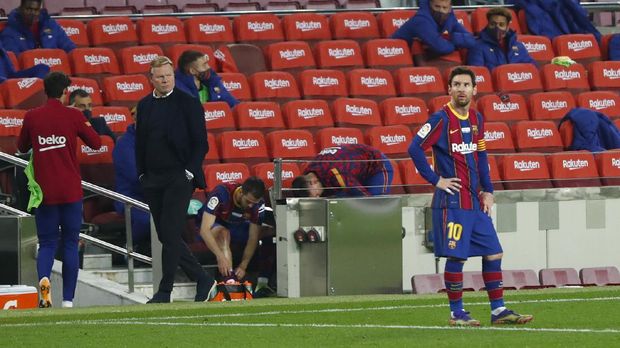 Barcelona's head coach Ronald Koeman, left looks at his player Barcelona's Lionel Messi during the Spanish La Liga soccer match between Barcelona and Valencia at the Camp Nou stadium in Barcelona, Spain, Saturday, Dec. 19, 2020. (AP Photo/Joan Monfort)