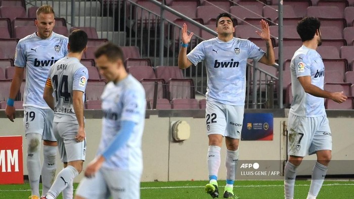 Valencias Uruguayan forward Maxi Gomez (2R) celebrates his goal during the Spanish league football match between FC Barcelona and Valencia CF at the Camp Nou stadium in Barcelona on December 19, 2020. (Photo by LLUIS GENE / AFP)