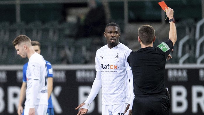 Referee Frank Willenborg shows Moenchengladbachs Marcus Thuram the red card during their German Bundesliga soccer match between Borussia Moenchengladbach and 1899 Hoffenheim at Borussia-Park in Moenchengladbach, Germany, Saturday, Dec. 19, 2020. (Marius Becker/dpa via AP)