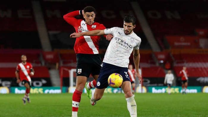 SOUTHAMPTON, ENGLAND - DECEMBER 19: Ruben Dias of Manchester City is challenged by Che Adams of Southampton during the Premier League match between Southampton and Manchester City at St Marys Stadium on December 19, 2020 in Southampton, England. A limited number of fans (2000) are welcomed back to stadiums to watch elite football across England. This was following easing of restrictions on spectators in tiers one and two areas only. (Photo by Adrian Dennis - Pool/Getty Images)
