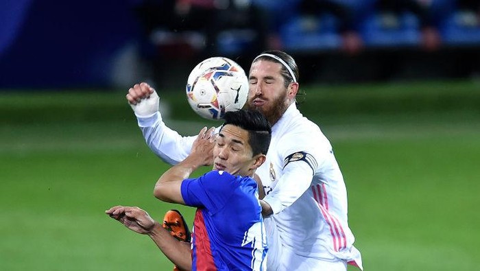 EIBAR, SPAIN - DECEMBER 20: Sergio Ramos of Real Madrid battles for possession with Yoshinori Muto of SD Eibar during the La Liga Santander match between SD Eibar and Real Madrid at Estadio Municipal de Ipurua on December 20, 2020 in Eibar, Spain. Sporting stadiums around Spain remain under strict restrictions due to the Coronavirus Pandemic as Government social distancing laws prohibit fans inside venues resulting in games being played behind closed doors. (Photo by Juan Manuel Serrano Arce/Getty Images)